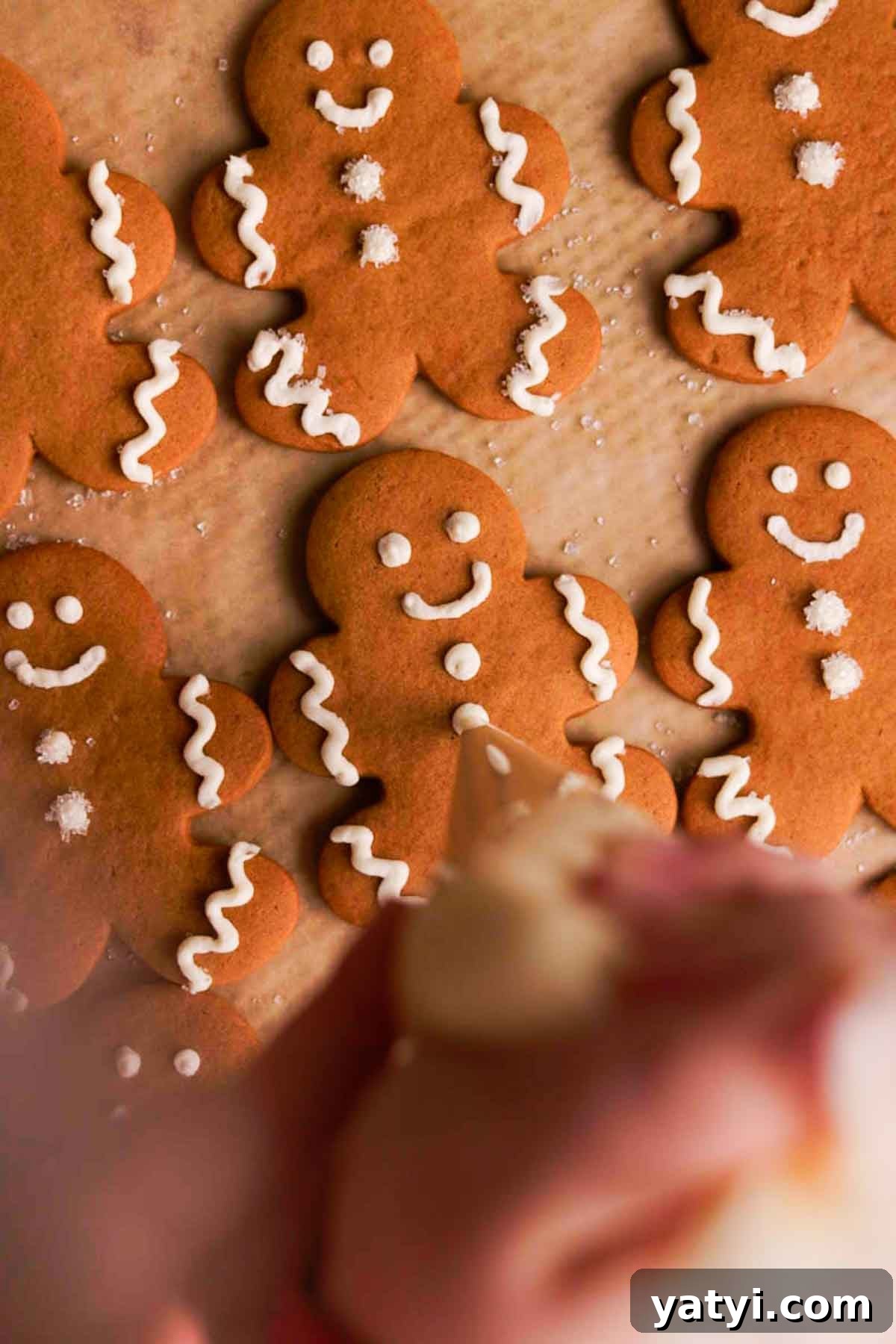 piping buttons on gingebread men cookies with plastic piping bag