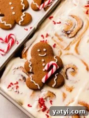 gingerbread cookie with candy cane on top of gingerbread cinnamon rolls