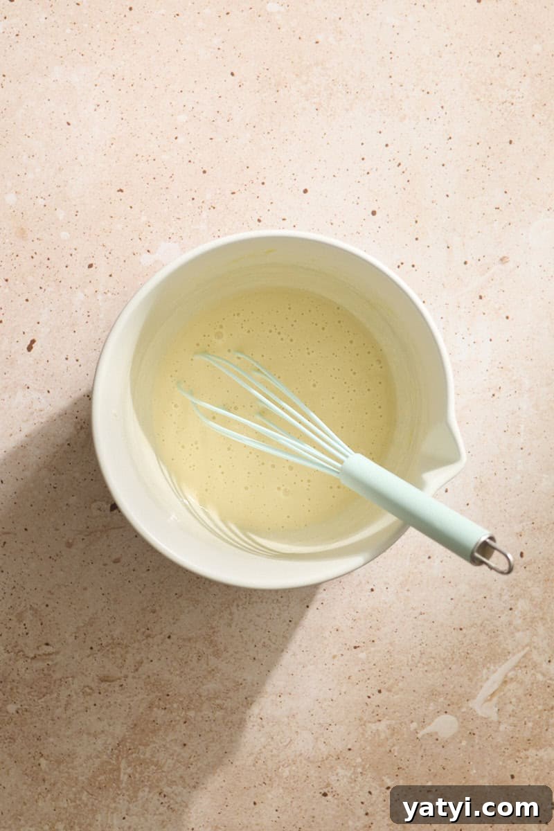 Sourdough Discard Scone Recipe: Flaky Base for Sweet or Savory Add-Ins 4 Wet ingredients mixed in a white bowl.