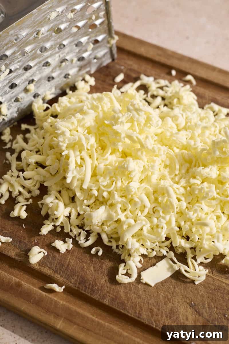 Sourdough Discard Scone Recipe: Flaky Base for Sweet or Savory Add-Ins 6 Grated butter on a wooden cutting board.