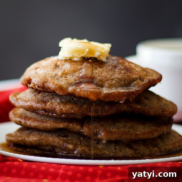 Buttermilk Apple Cinnamon Pancakes with Brown Sugar Glaze 2 A stack of Apple Cinnamon Pancakes with butter and maple syrup.