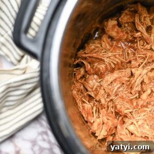 barbecue chicken covered in sauce in an instant pot, towel beside it.