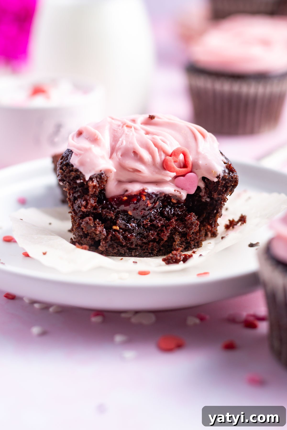 Moist Chocolate Cupcakes with Raspberry Filling and Ganache 3 chocolate raspberry cupcake with a bite missing showing the raspberry jam filling