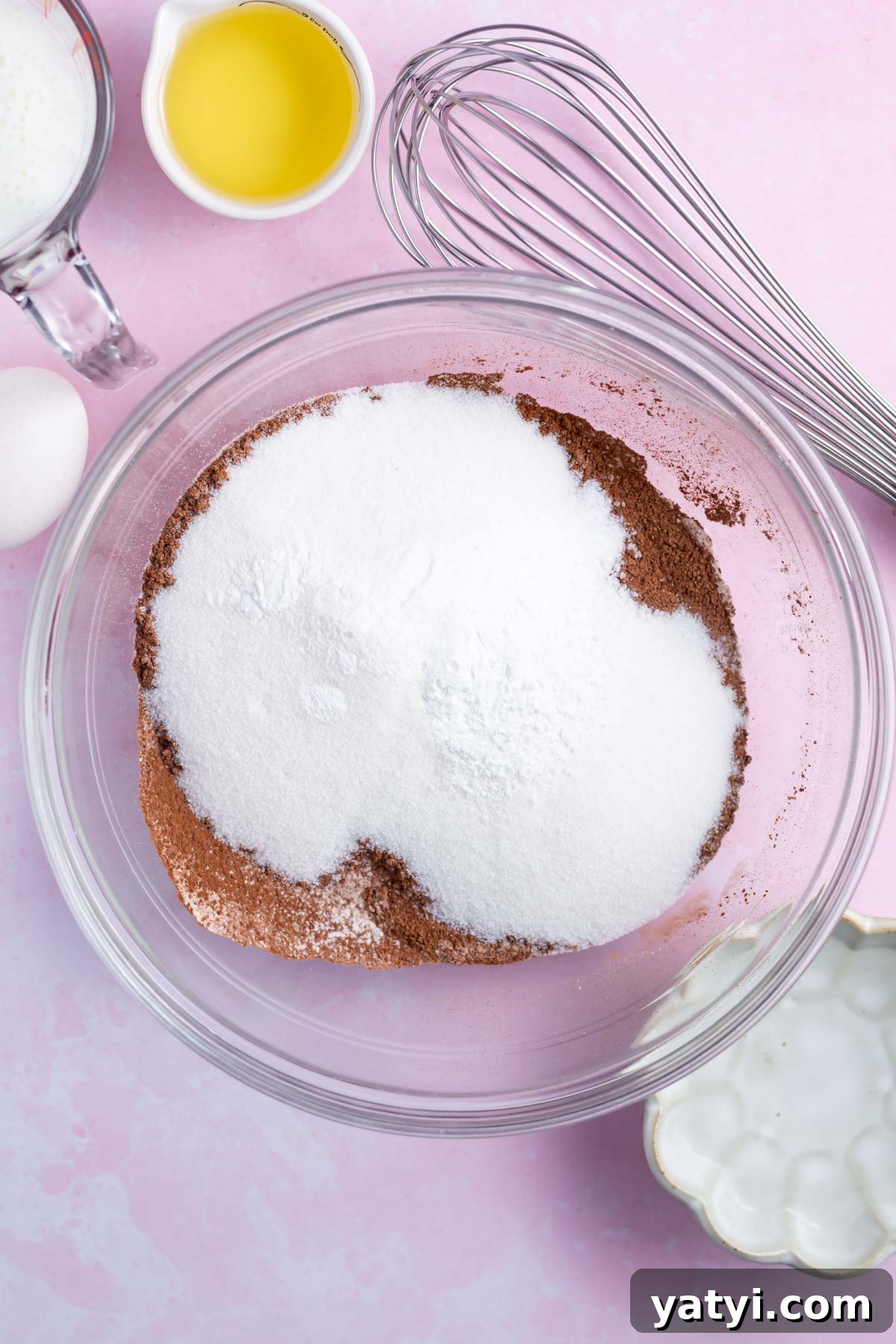 Moist Chocolate Cupcakes with Raspberry Filling and Ganache 10 flour, sugar, baking soda and kosher salt in a mixing bowl with a whisk nearby.