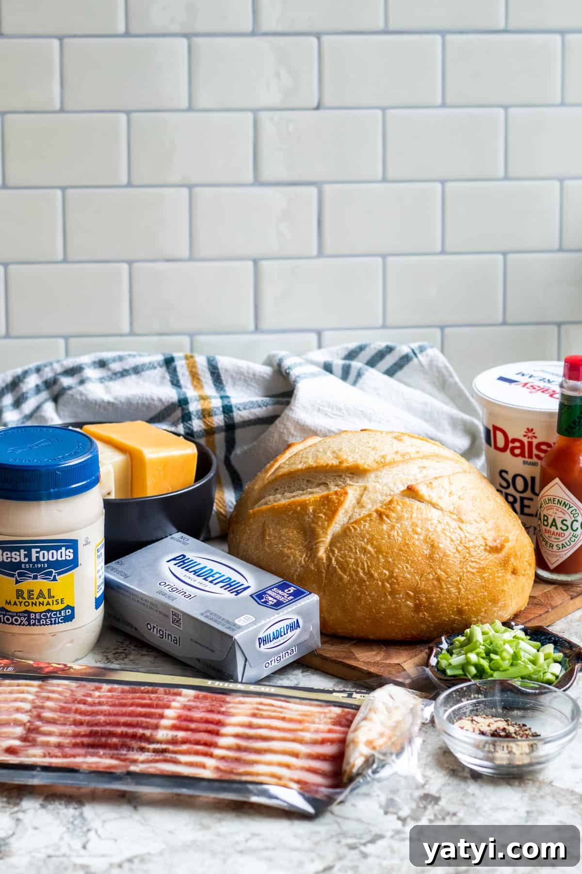 Baked Bacon and Cheese Dip Served in a Warm Bread Bowl 3 Recipe ingredients laid out on counter.