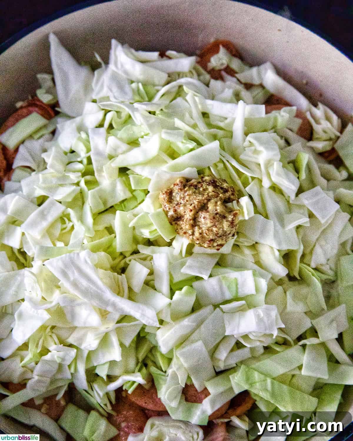 Savory Sausage and Cabbage Skillet Recipe for Weeknight Dinners 9 adding cabbage to the skillet.