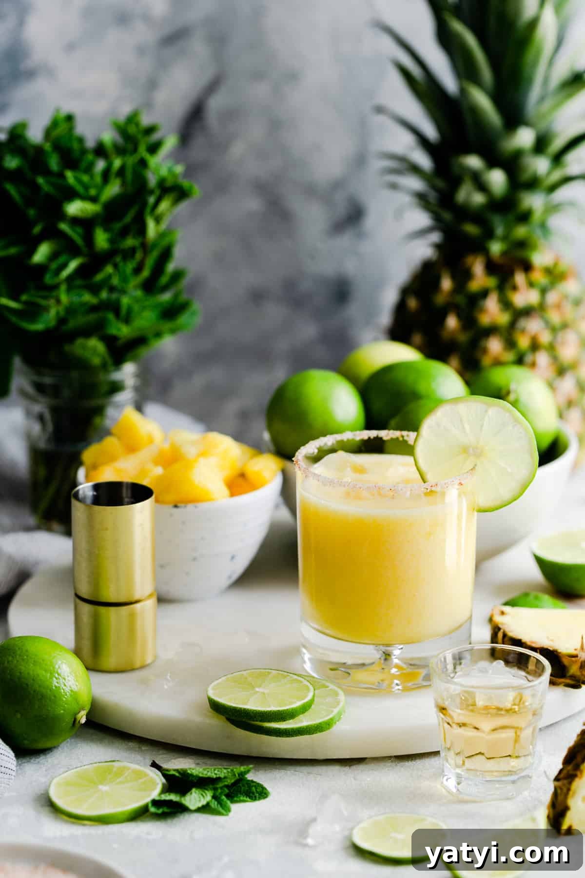 Frozen Pineapple Margarita Recipe — Tropical Cocktail Guide 8 glass of frozen pineapple margarita on a marble chopping board