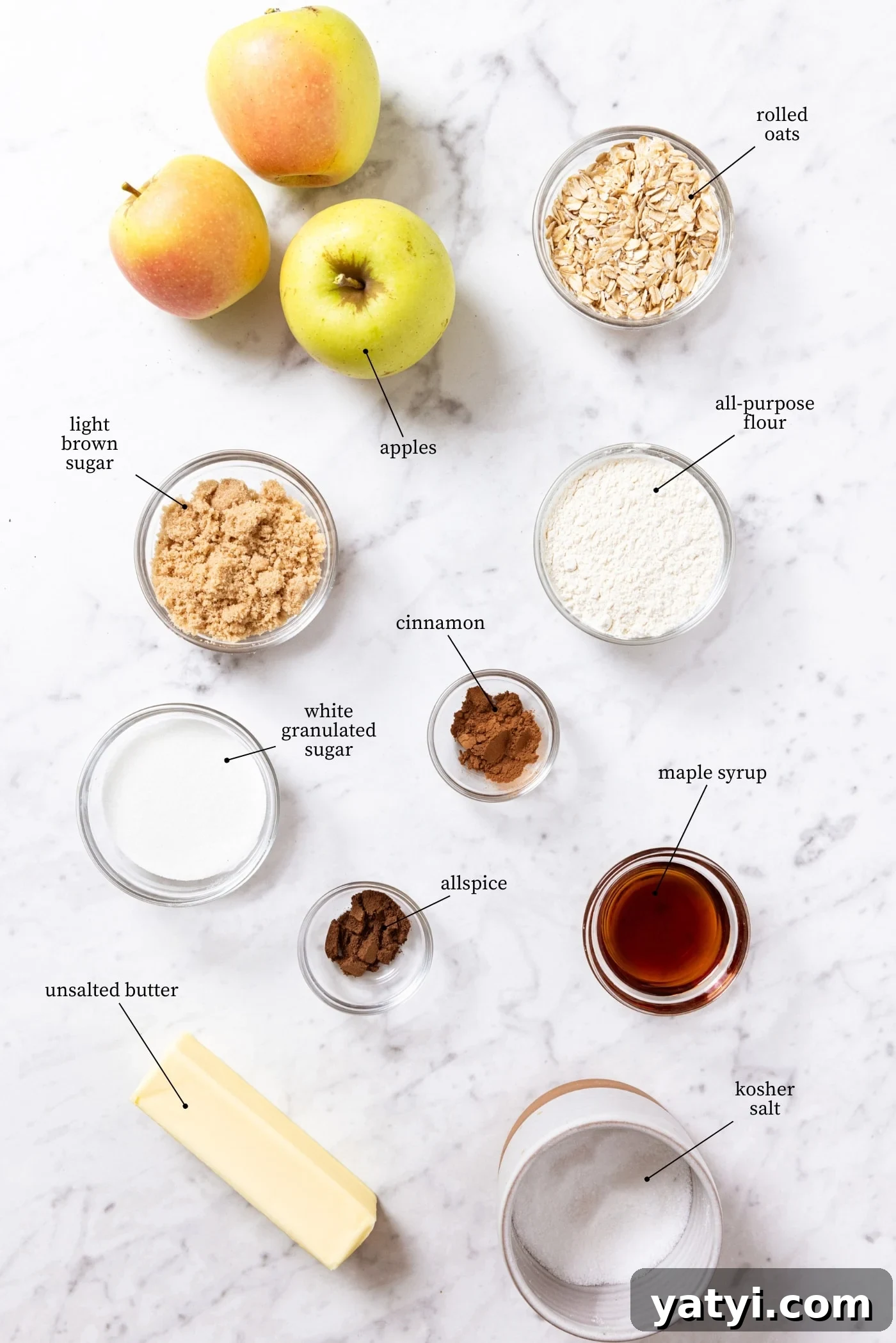 Chewy Cinnamon Apple Pie Bars: Easy Recipe for Fall Baking 4 White marble surface filled with all ingredients needed to make apple pie bars including sugars, apples, oats, maple syrup, spices, and more.