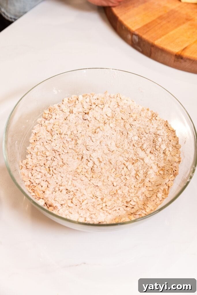 Chewy Cinnamon Apple Pie Bars: Easy Recipe for Fall Baking 6 Combined mixture of sugars with flour in a large glass measuring bowl on a white surface.