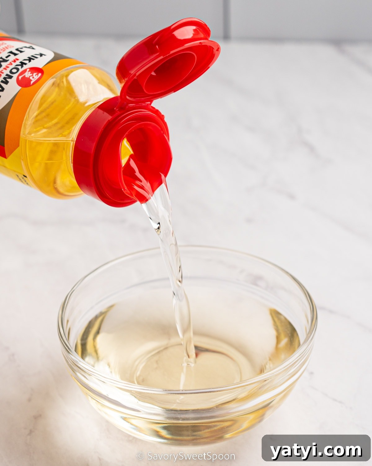 Mirin Substitutes: What to Use Instead of Mirin in Recipes 3 Bottle of mirin pouring into glass bowl.