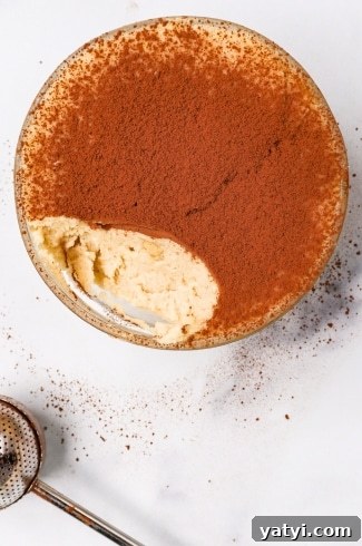 Keto Tiramisu Cottage Cheese Cookie Dough with one bite taken out with cocoa powder duster