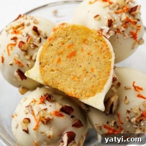 Keto Carrot Cake Protein Bites Recipe for Low-Carb Snacks 19 Keto carrot cake bites coated in white chocolate with chopped pecans and shredded carrot, one bitten to reveal the inside