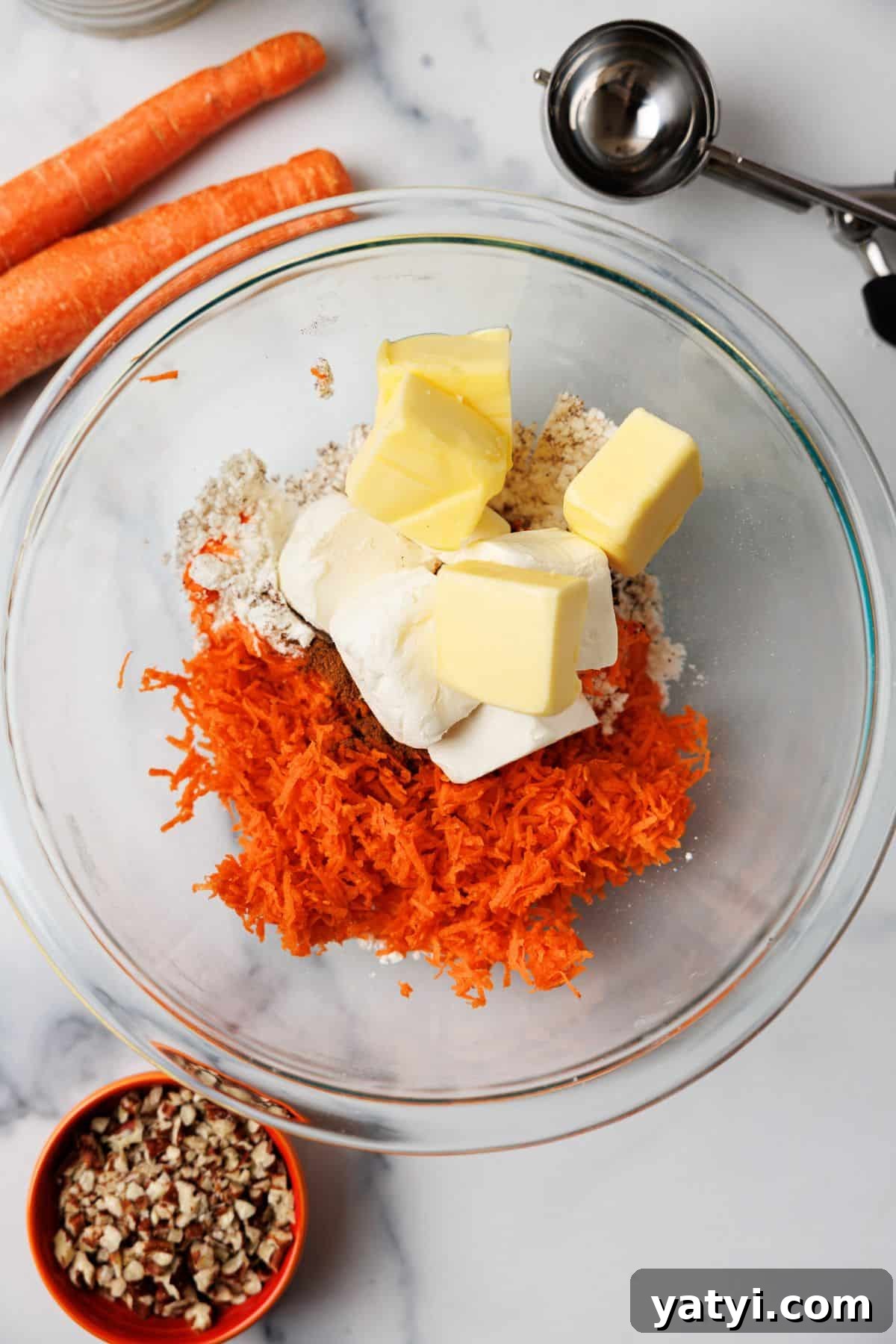 Keto Carrot Cake Protein Bites Recipe for Low-Carb Snacks 4 Glass bowl with grated carrots, cream cheese, butter, and protein powder before mixing