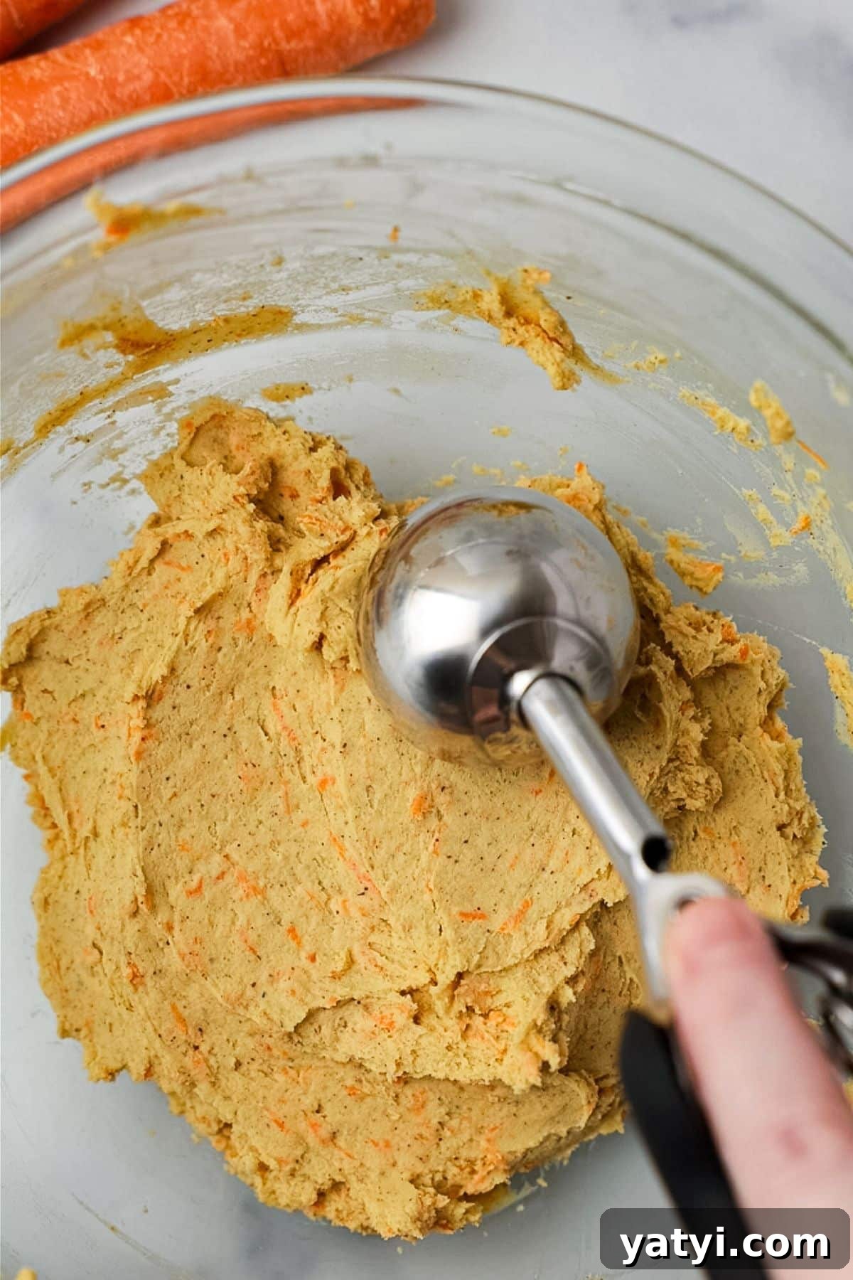 Keto Carrot Cake Protein Bites Recipe for Low-Carb Snacks 6 Cookie scoop portioning the carrot cake bite mixture from a glass bowl