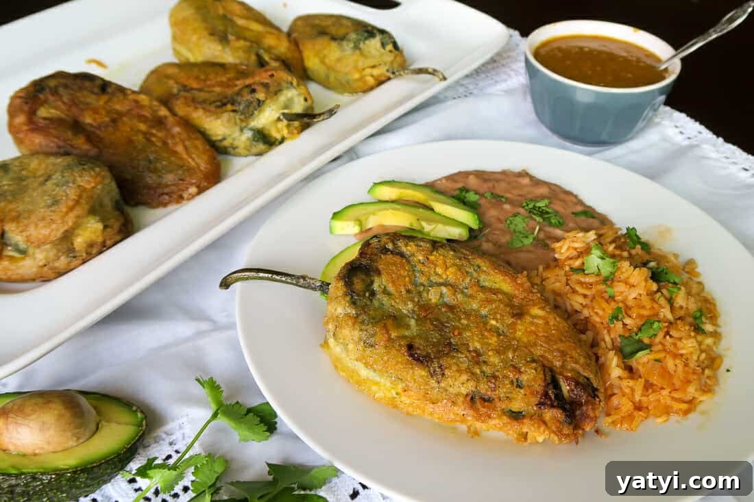 Authentic Chiles Rellenos: Mom’s Homemade Recipe with Video 5 authentic chiles rellenos served with a side of salsa, beans, rice and avocado slices