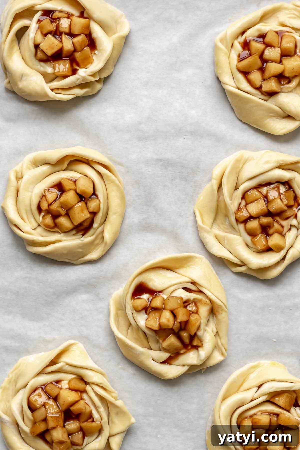 Apple pie filling in the center of all puff pastry roses.