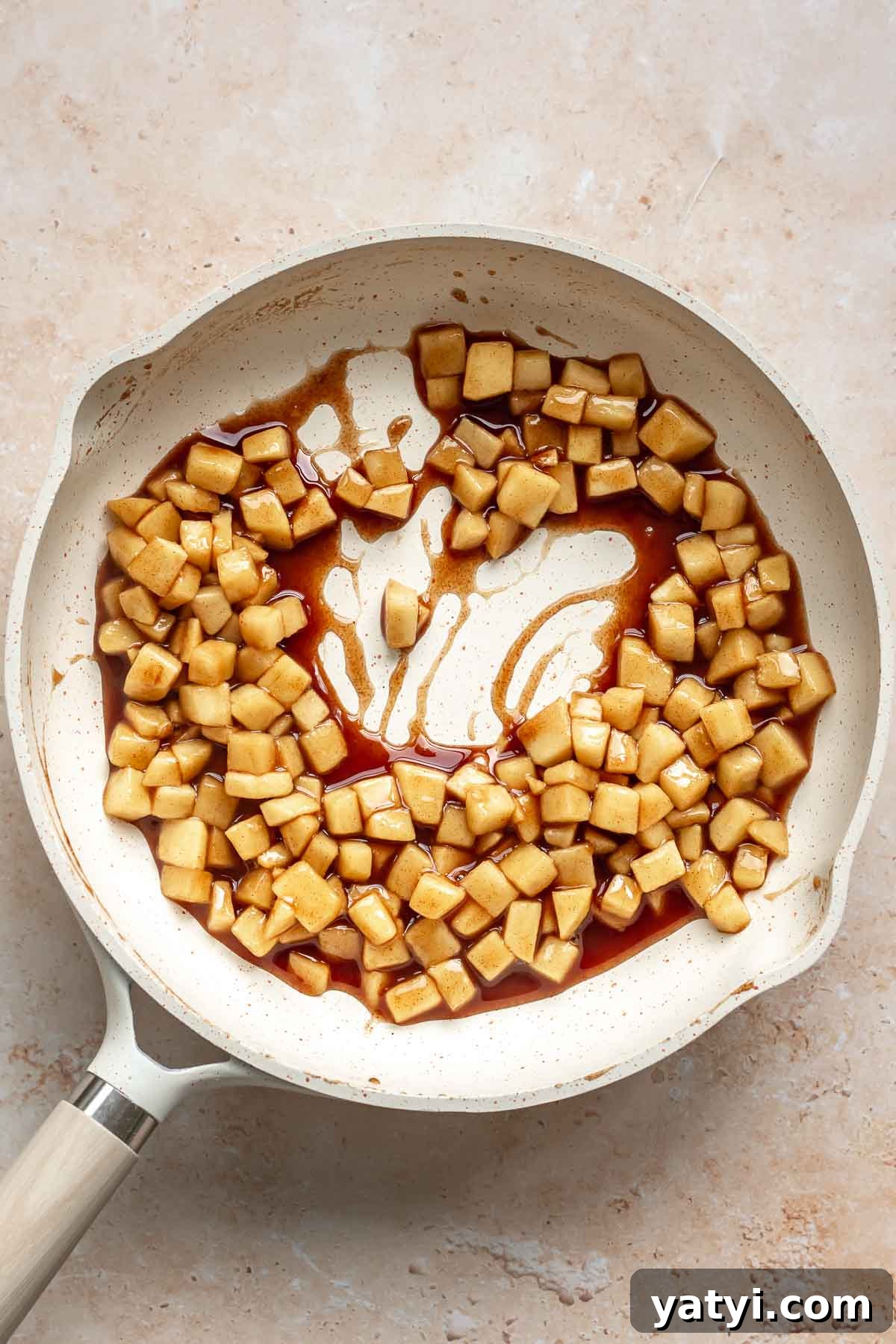 Cooked spiced apples in a frying pan.