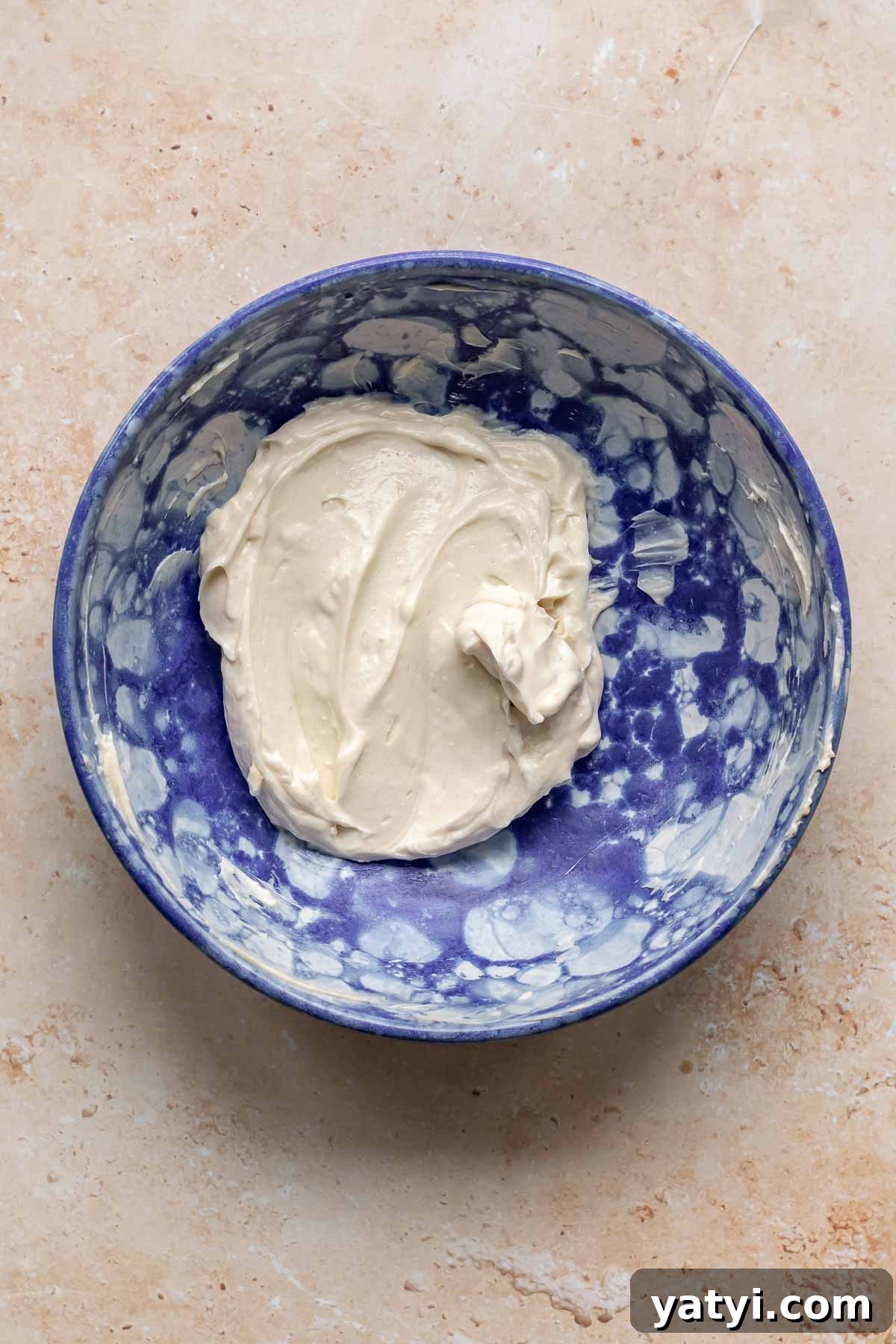 Cream cheese and sugar mixed together in a bowl.