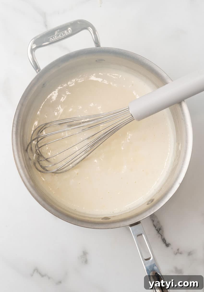 Creamy White Chicken Lasagna Roll-Ups for Family Dinner 5 homemade cream sauce in a large metal skillet
