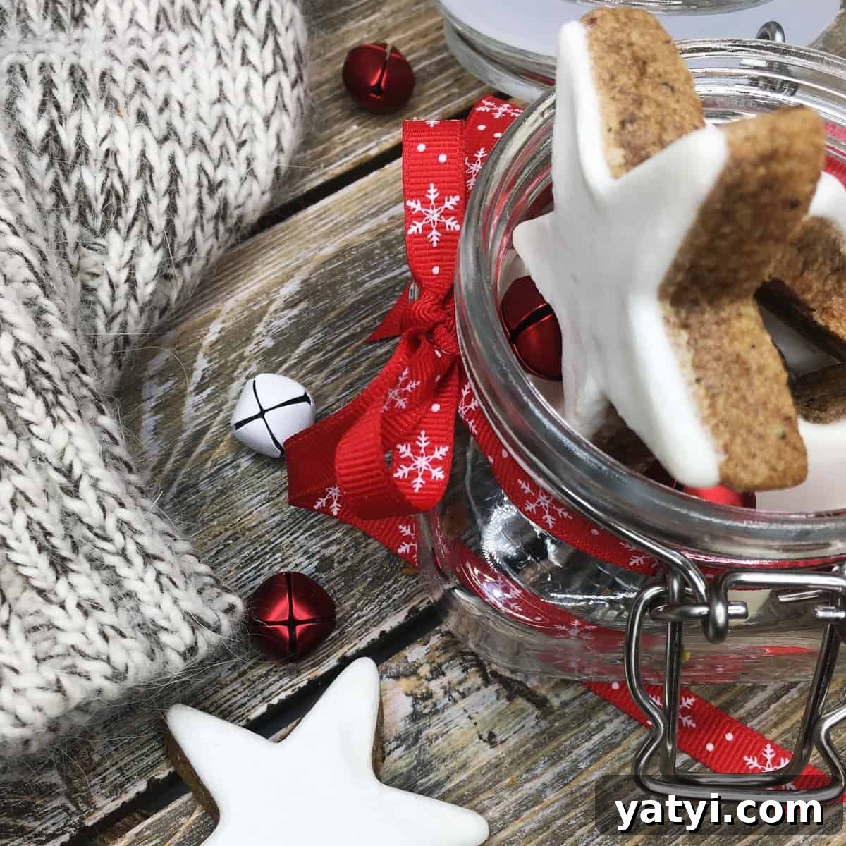 A batch of German cinnamon star cookies in a jar on a wooden board.