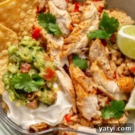 Finished Instant Pot chicken fajitas served with tortilla chips, sour cream, cilantro, and fresh lime.