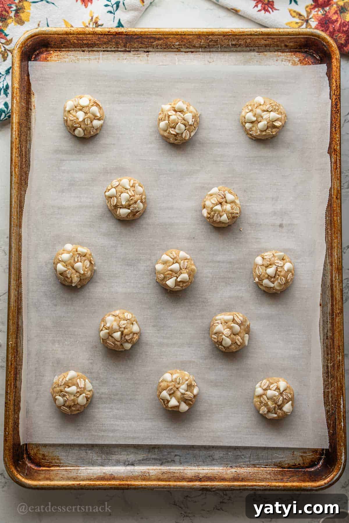 Raw coconut oatmeal cookie dough balls on tray.