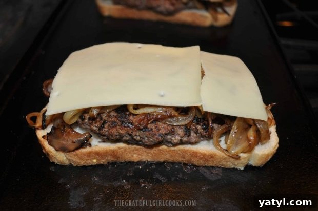 Grilled Patty Melt / The Grateful Girl Cooks! Swiss cheese slices are placed on top of onions on patty melt.