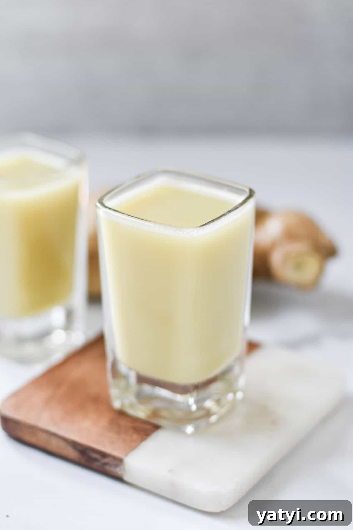 Ginger Juice Recipe: Make Fresh Ginger Juice with a Blender or Juicer 2 A shot of ginger juice on a coaster.
