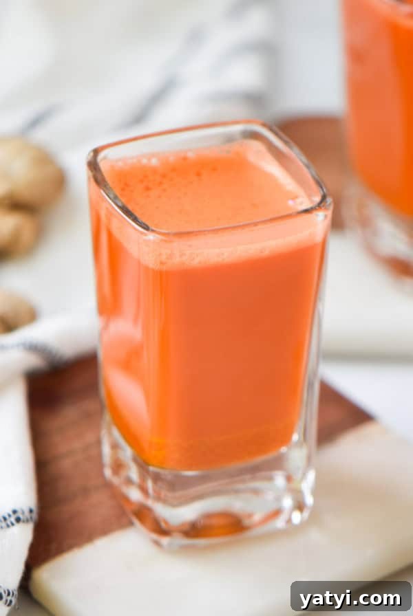 Ginger Juice Recipe: Make Fresh Ginger Juice with a Blender or Juicer 12 Two carrot wellness shots next to fresh ginger root.