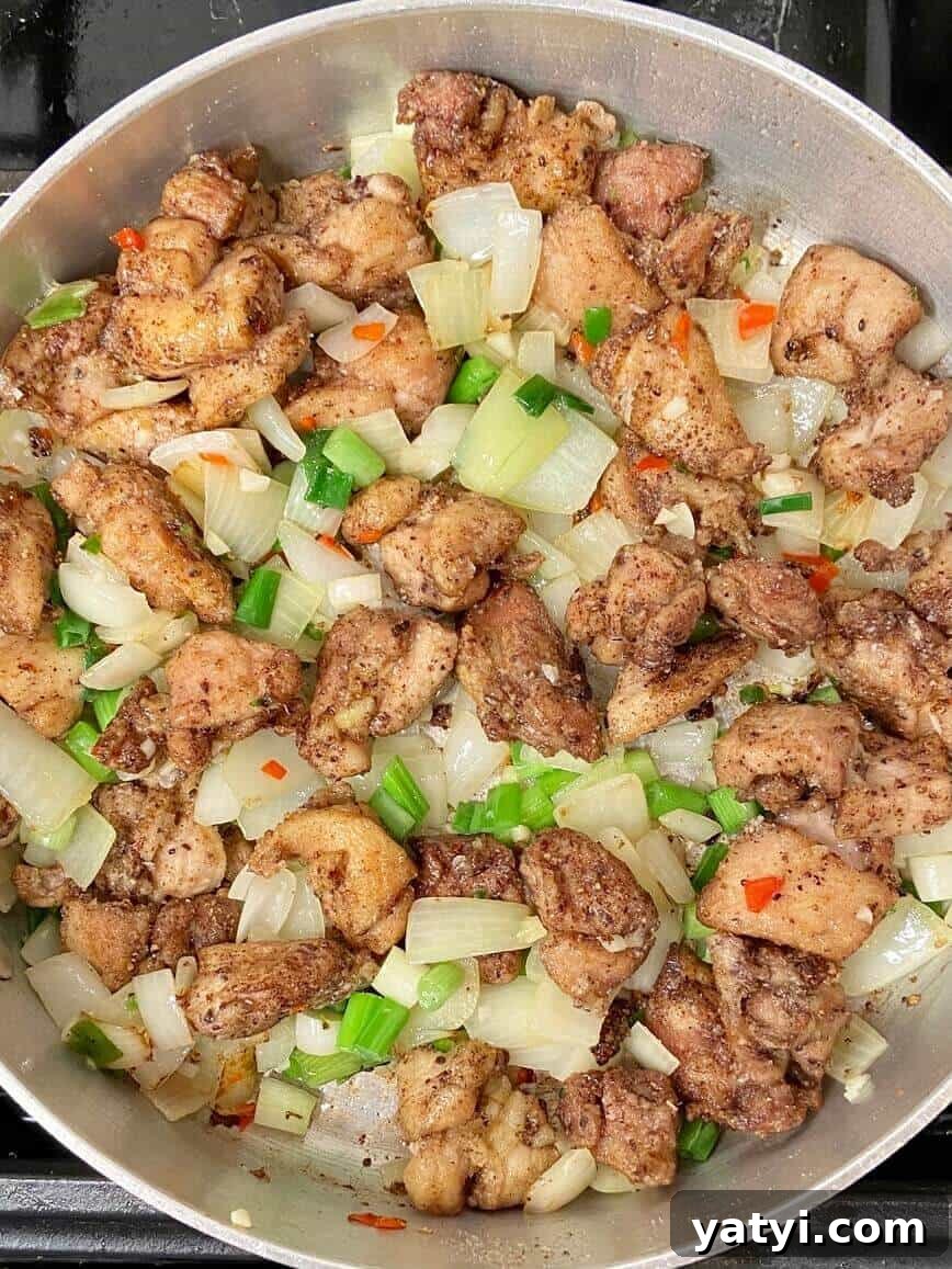 Cooking the chicken and vegetables in a pan.