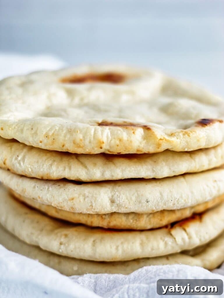 Gluten-Free Pita Bread Recipe: Soft, Flavorful, and Simple 7 stack of several pita bread on white towel.