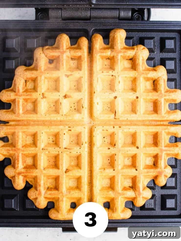 Fluffy Buttermilk Pumpkin Waffles Recipe for Fall Breakfast 5 Overhead view of cooked waffle on a waffle iron.