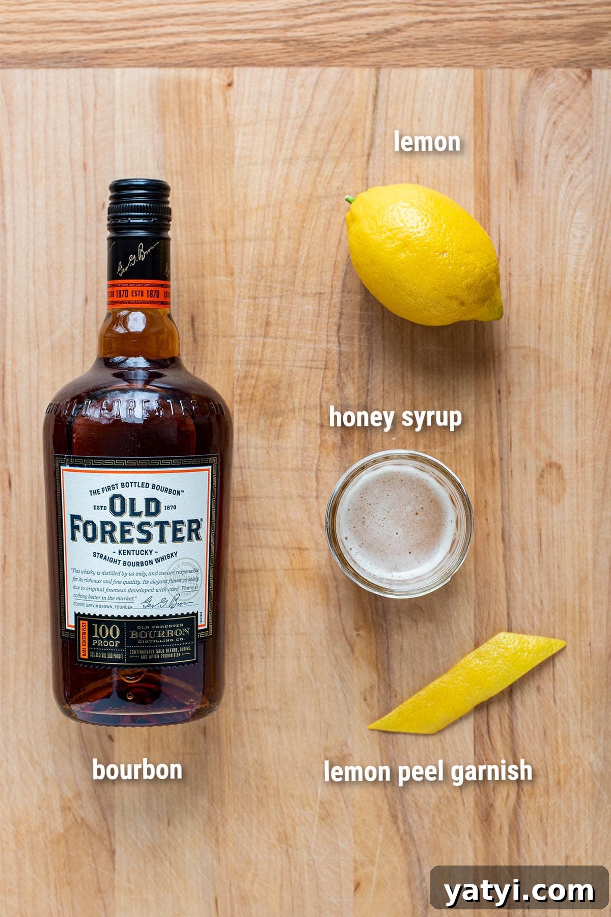Gold Rush Whiskey Cocktail Recipe: Classic Honey-Lemon Sour 3 Gold Rush cocktail ingredients laid out on a wooden cutting board.