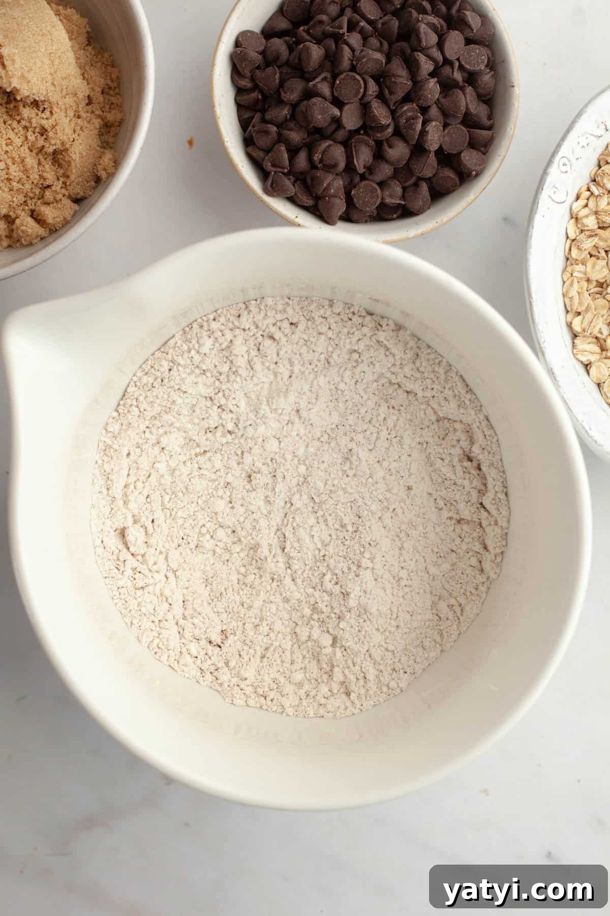 Chewy Brown-Butter Oatmeal Cookies with Chocolate Chips 5 A large white bowl with flour in it.