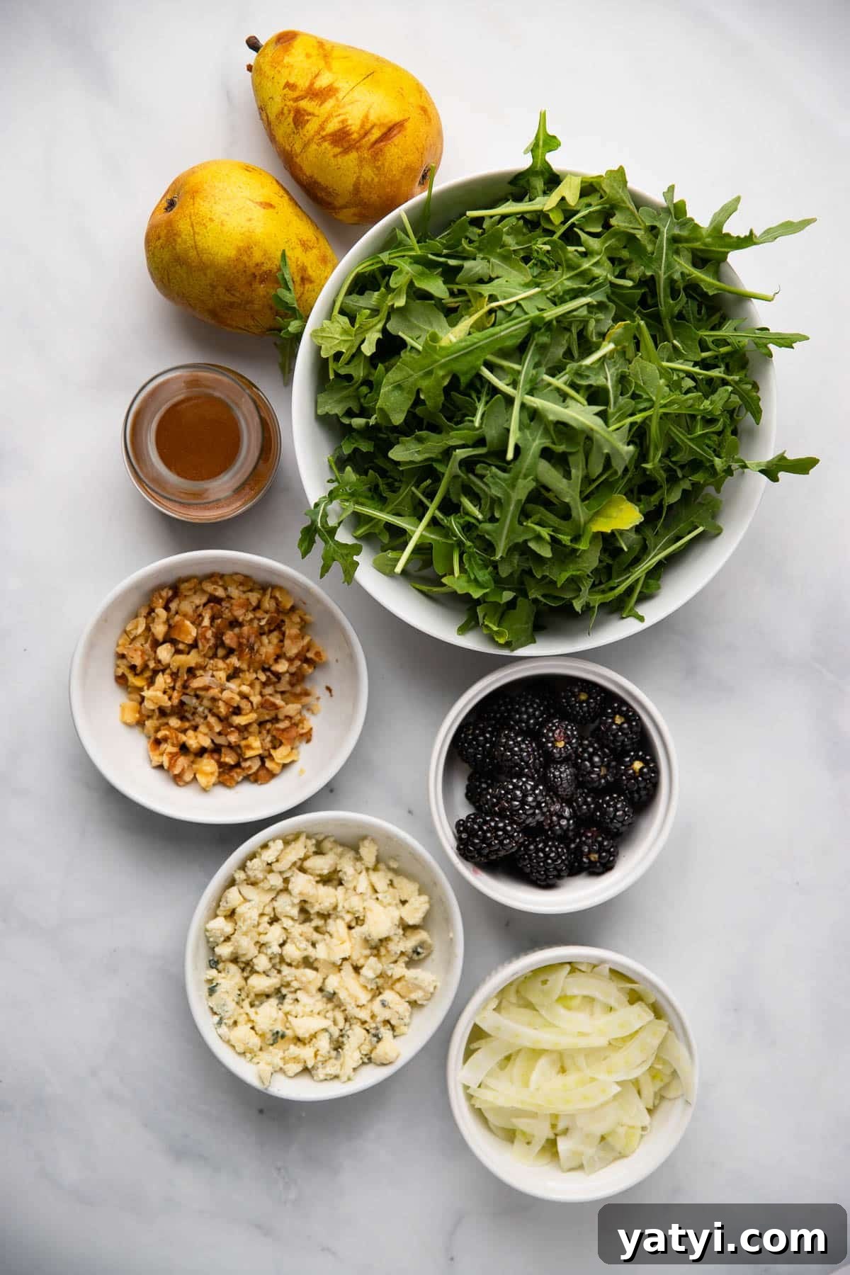 Pear, Walnut and Gorgonzola Salad with Honey-Balsamic Dressing 2 pear salad ingredients in small bowls on a white background.