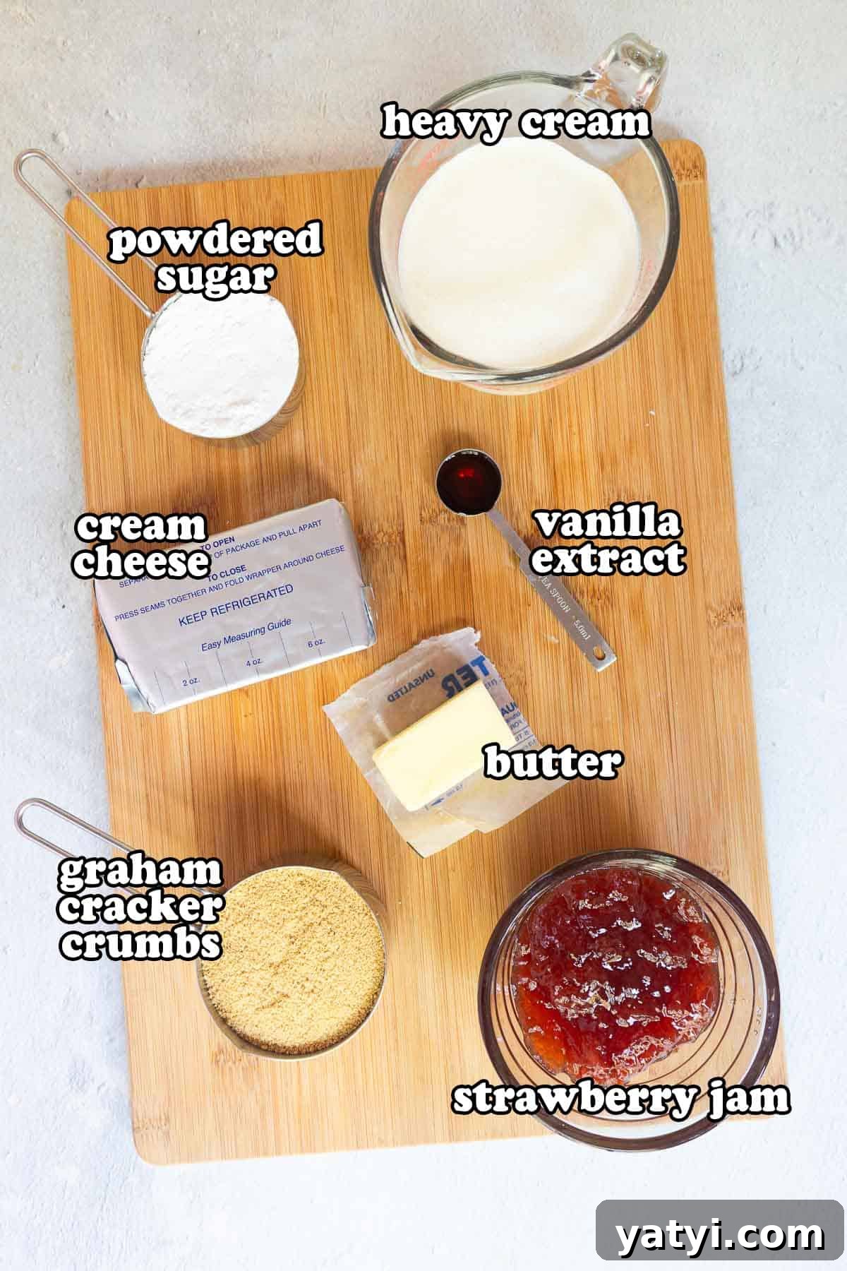 No-Bake Strawberry Cheesecake Cups with Graham Cracker Crust 3 Ingredients on a wooden board: cream cheese, powdered sugar, heavy cream, vanilla extract, butter, graham cracker crumbs, and strawberry jam.