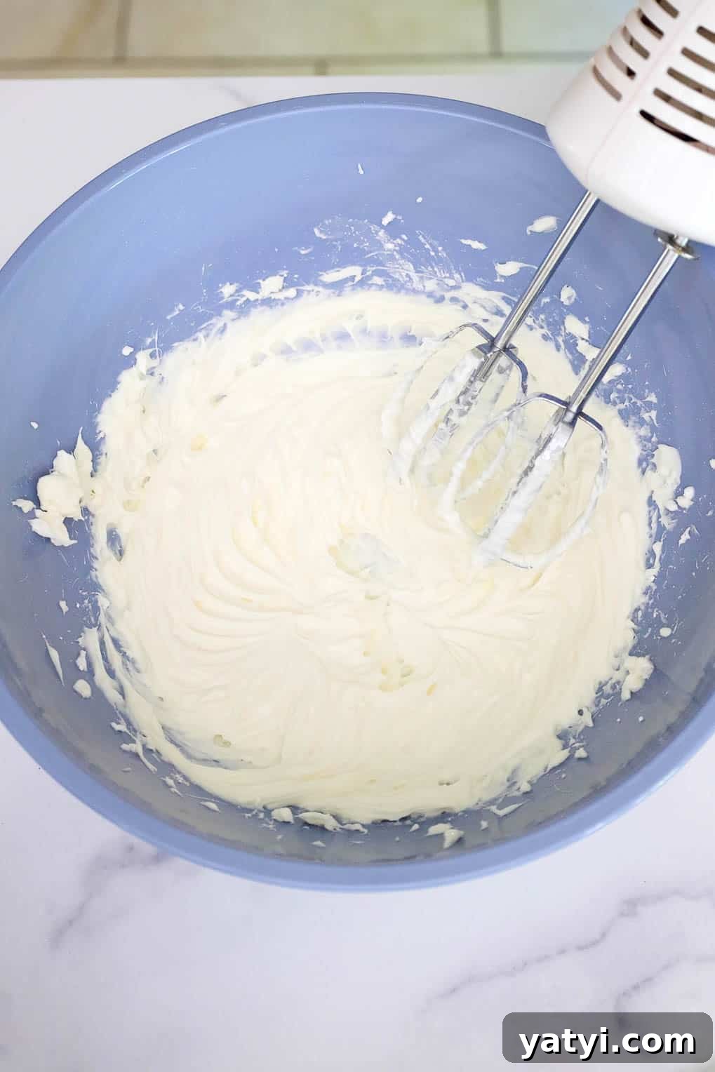 No-Bake Strawberry Cheesecake Cups with Graham Cracker Crust 5 Cream cheese mixture whipped in a mixing bowl after beating with an electric mixer.