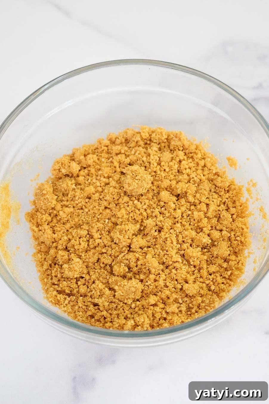 No-Bake Strawberry Cheesecake Cups with Graham Cracker Crust 7 Thick crumble of crushed graham cracker and butter mixture in a glass bowl.