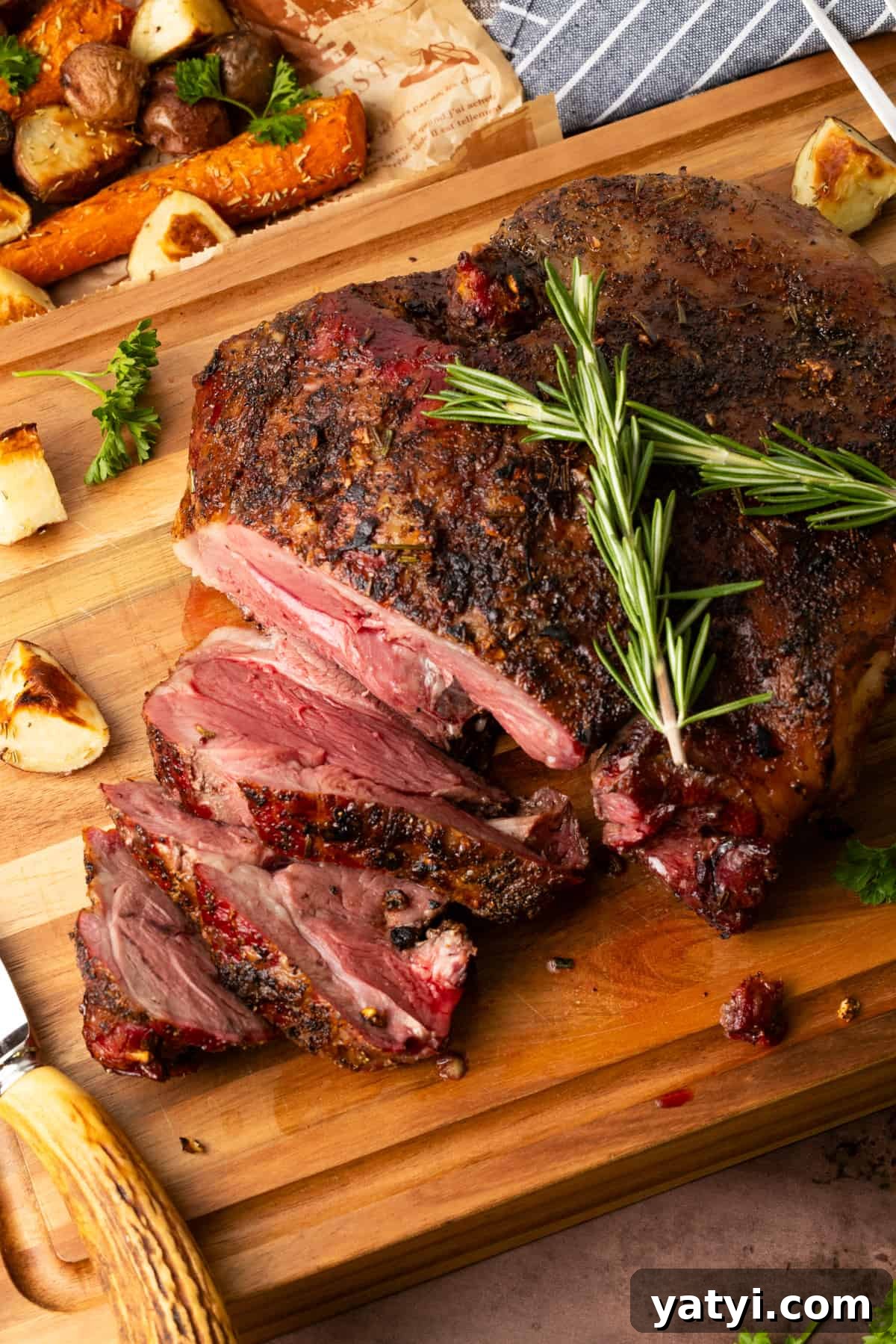 Juicy Smoked Leg of Lamb Recipe for Tender, Flavorful Roast 2 Leg of lamb on cutting board with rosemary atop roast.