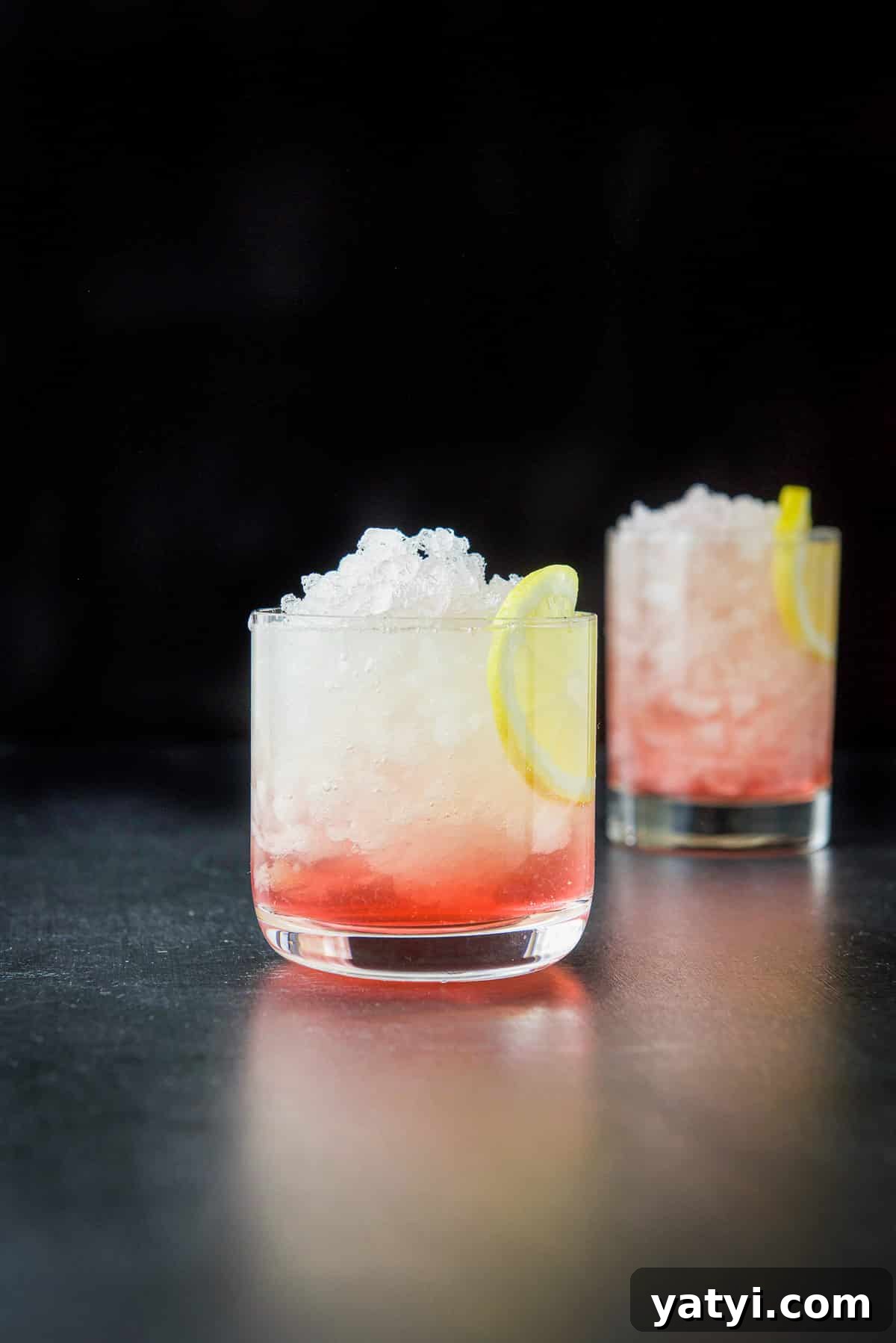 How to Make a Classic Bramble Cocktail: Gin, Blackberry & Lemon 2 Vertical view of two glasses filled with the bramble cocktail with lemon as garnish