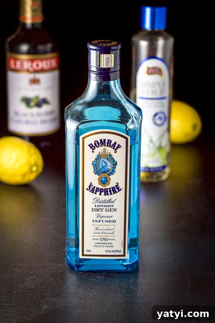 How to Make a Classic Bramble Cocktail: Gin, Blackberry & Lemon 3 Gin, Blackberry liqueur, simple syrup and lemons on the black table