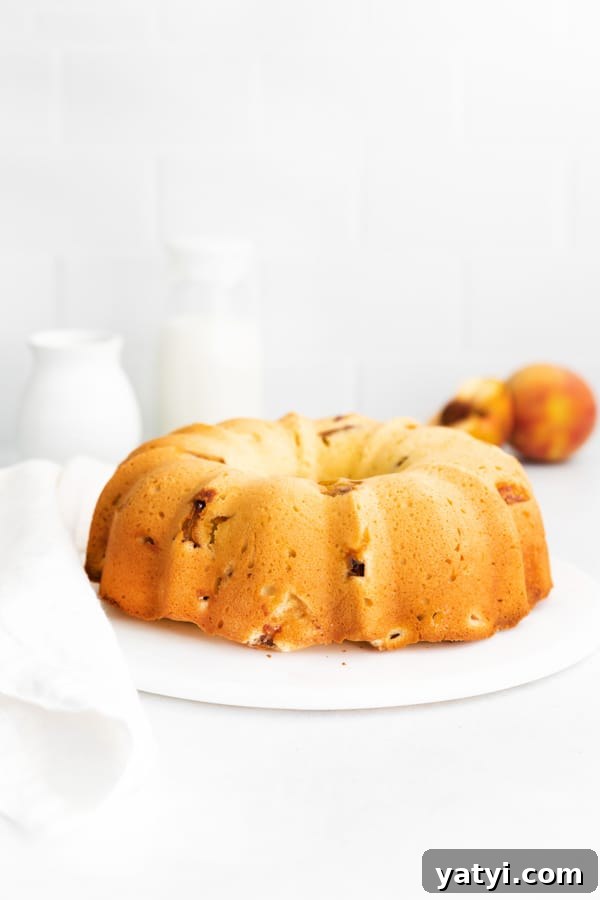 Glazed Peach Bundt Cake Recipe with Fresh Summer Peaches 6 a full Peach Bundt Cake sitting on a marble cake plate.