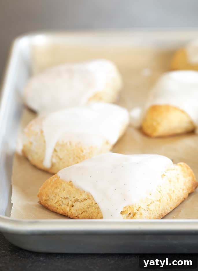 Gluten-Free Vanilla Scones Inspired by Starbucks 3 Miniature vanilla scones with white icing on a tray