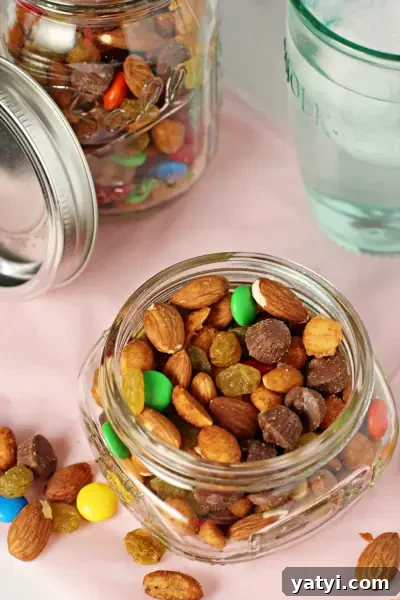 This homemade trail mix with chocolate and nuts is incredibly easy to make and completely customizable to fit your own preferences! Stop buying the stuff from the store and make your own instead! An open glass jar of Chocolate Trail Mix.