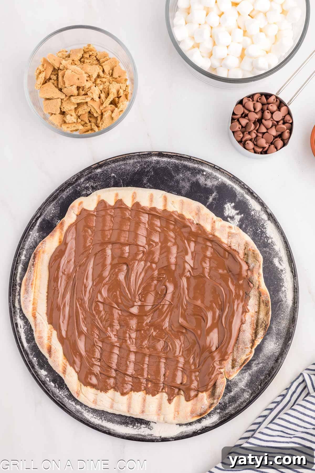 Spreading nutella on the cooked dough on the pizza crust