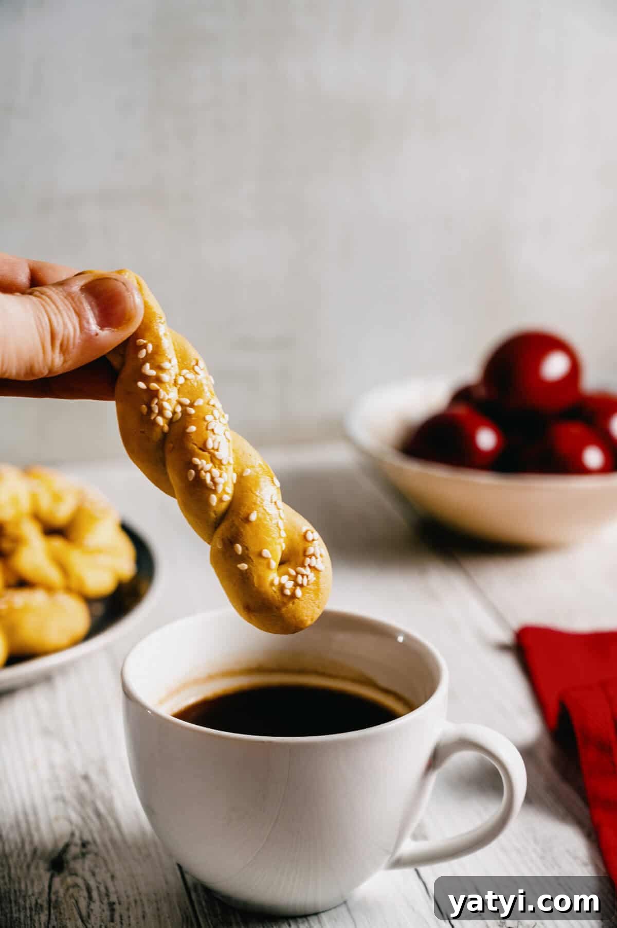 Greek Easter Traditions: Customs, Foods, and Celebrations Explained 13 a Greek easter cookie being dunked into a cup of coffee.