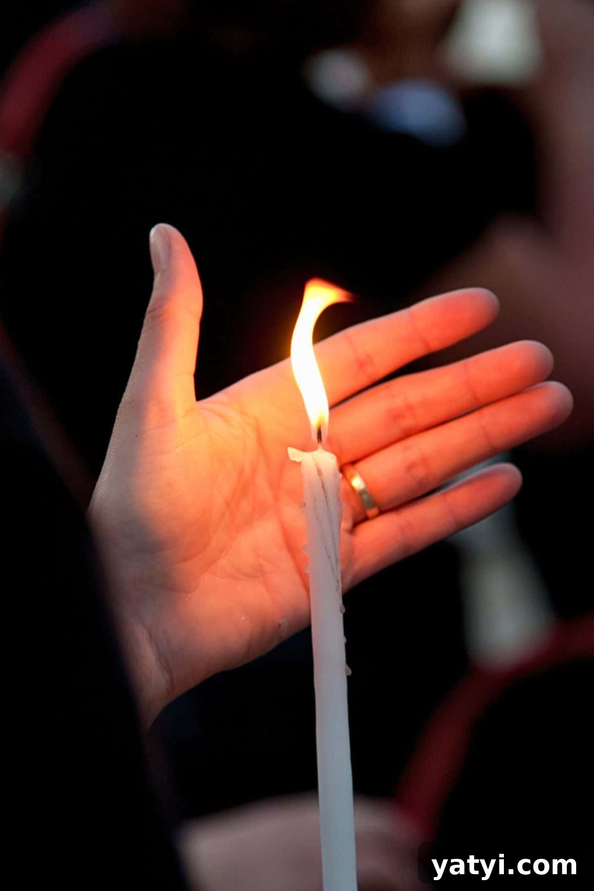 Greek Easter Traditions: Customs, Foods, and Celebrations Explained 14 a hand protecting the Holy Light after Greek Easter church service.