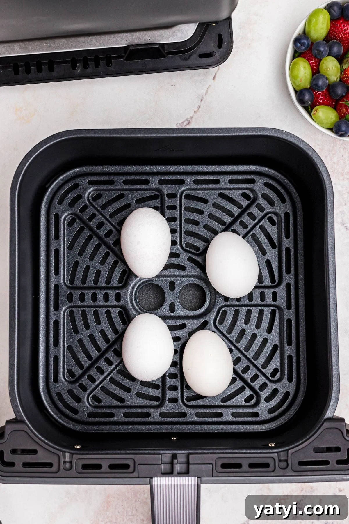 Perfect Soft-Boiled Eggs in an Air Fryer 4 Four white eggs in shell, in the air fryer basket.