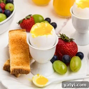 Perfect Soft-Boiled Eggs in an Air Fryer 8 Slightly runny yolk inside of an egg shell in an egg holder with fruit and toast.