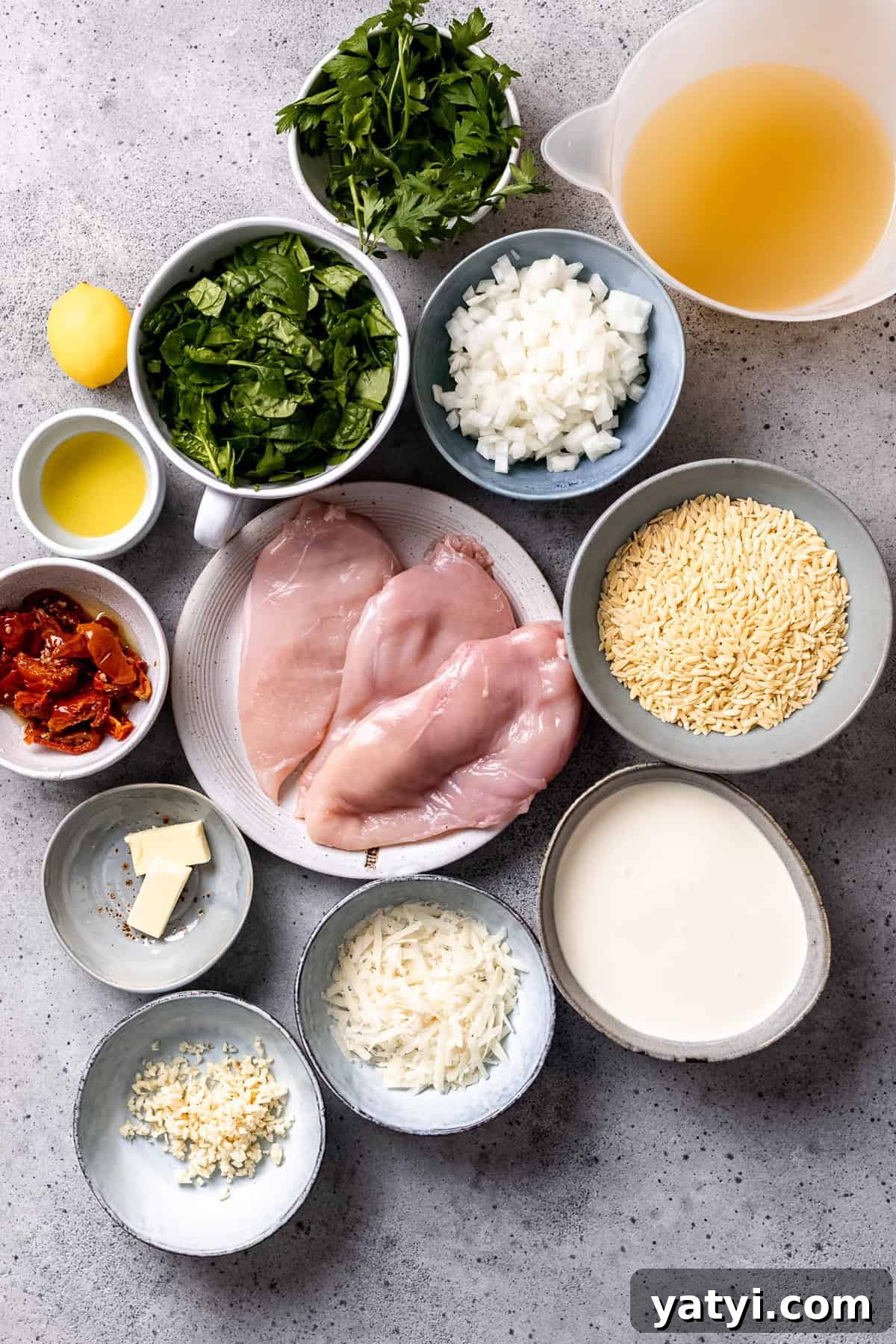 Tuscan Chicken Orzo with Sun-Dried Tomatoes and Spinach 3 Ingredients for Tuscan chicken and orzo on a blue table.